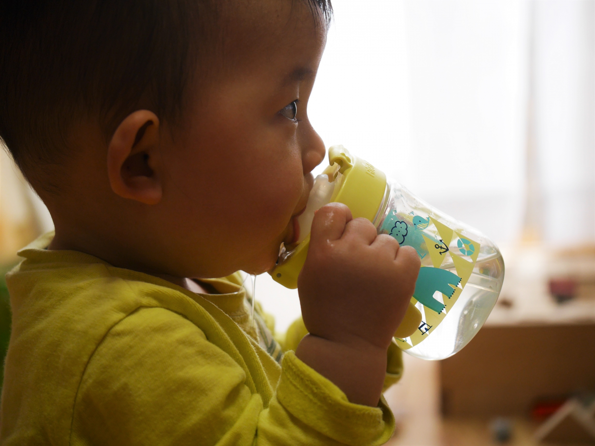 マグで飲む赤ちゃん